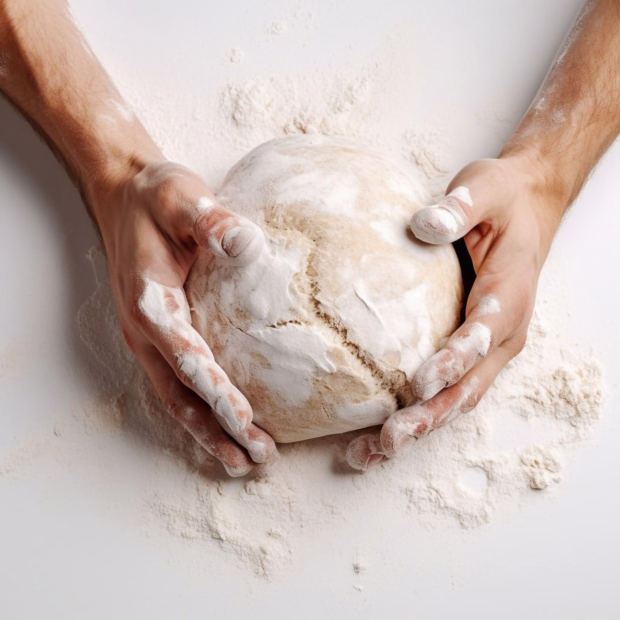 Chef shaping fresh sourdough in rustic kitchen